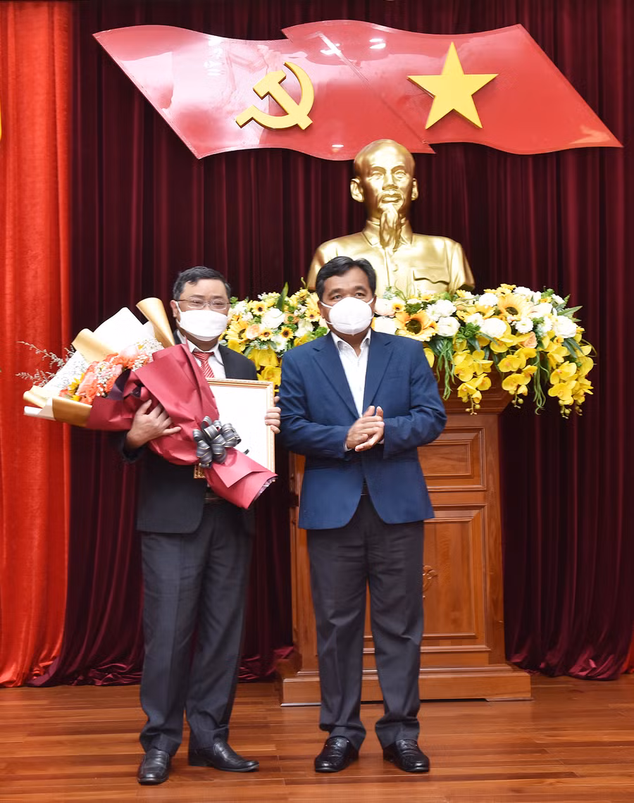 Bí thư Tỉnh ủy Hồ Văn Niên (bìa phải) trao quyết định và tặng hoa chúc mừng cho Phó Chủ nhiệm Ủy ban Kiểm tra Tỉnh ủy Phan Quang Thái. Ảnh: Đức Thụy