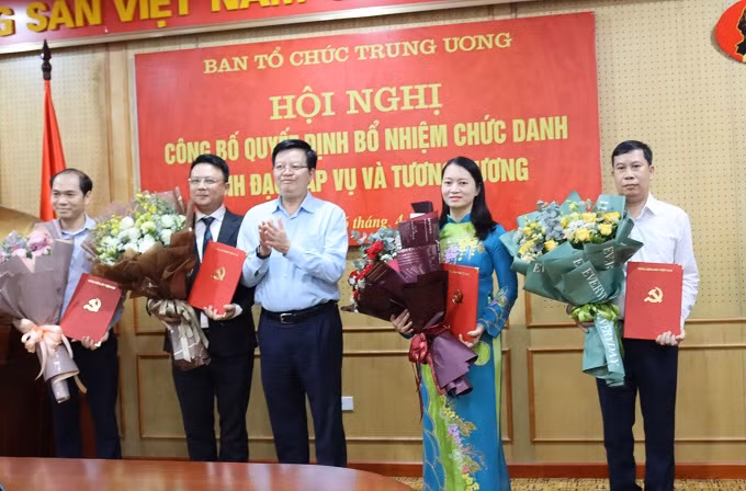 Đồng chí Mai Văn Chính tặng hoa chúc mừng các đồng chí được bổ nhiệm.