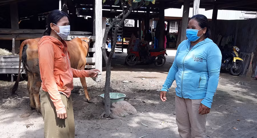 Chị H'Đa (bên phải) trao đổi với chị Ksor HTlun về các biện pháp phòng chống bệnh viêm da nổi cục ở trâu bò. Ảnh: Mai Linh