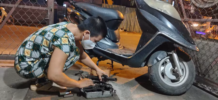 Chồng mất, chỉ còn mình chị Phương Tú sửa xe. Ảnh: Như Lịch