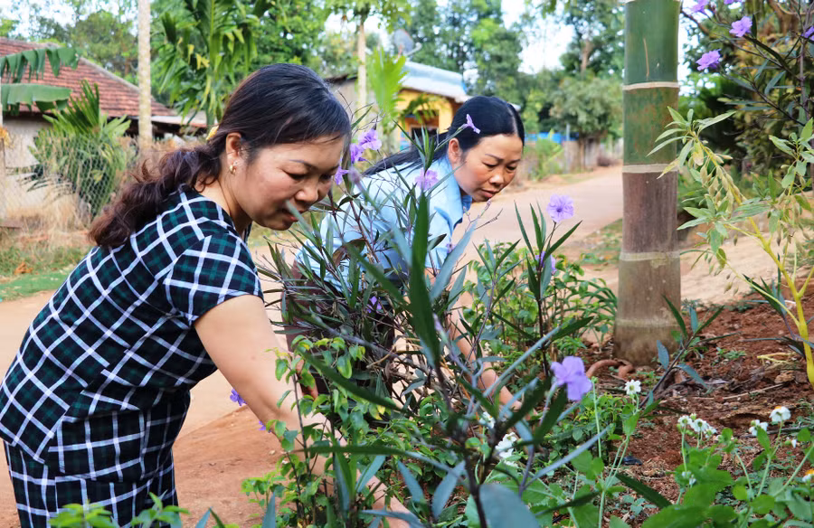 Chị em phụ nữ thôn 1 chăm sóc con đường hoa. Ảnh: Trần Dung Chị em phụ nữ thôn 1 chăm sóc con đường hoa. Ảnh: Trần Dung