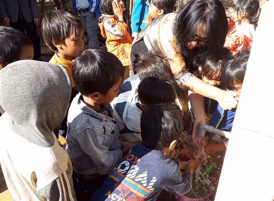 Trưởng nhóm thiện nguyện “Rau, củ, quả” TP. Hồ Chí Minh cùng các em khởi động công trình giếng khoan. Ảnh: Lê Trang