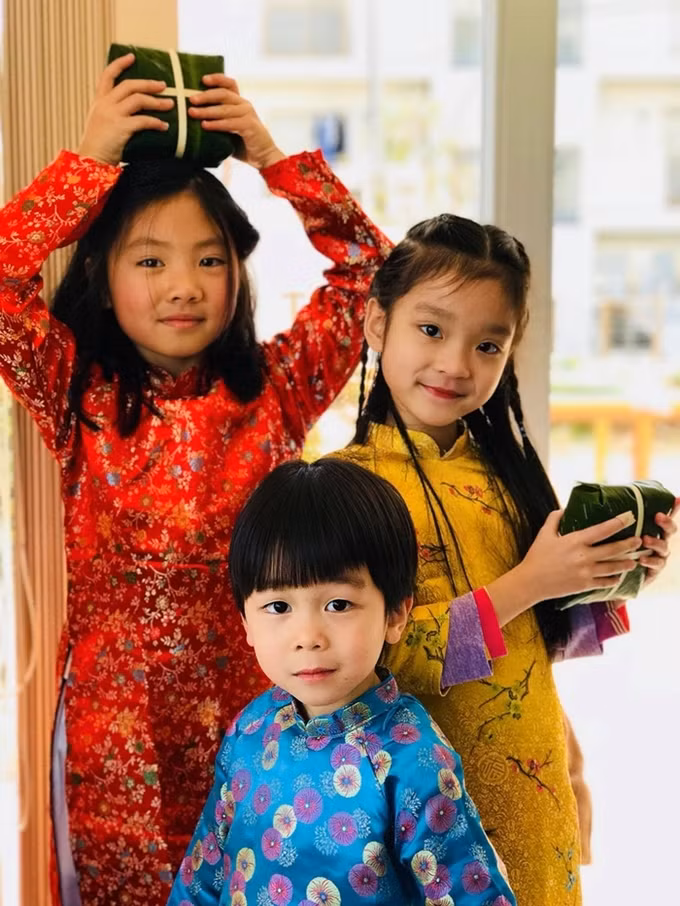 Con em người Việt tại Nhật mặc áo dài, bên những chiếc bánh chưng mới gói. 