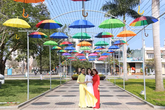  Những cô gái trẻ thướt tha với tà áo dài dưới con đường rợp bóng dù
