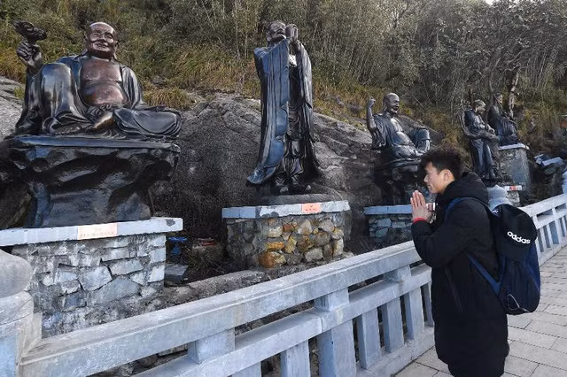 Từ đại tượng Phật, con đường La Hán giống như đường dẫn vào cõi Phật linh thiêng. Bên này đường, những gốc đỗ quyên hàng trăm tuổi xòa xuống những nụ mầm căng đầy sức sống trong giá rét. 18 bức tượng La Hán bằng đồng cao 2,5m mang đến nhân gian đủ sắc thái cảm xúc nhân từ, độ lượng. Bên kia lối đi lát đá ấy là khói sương bảng lảng mây bay.