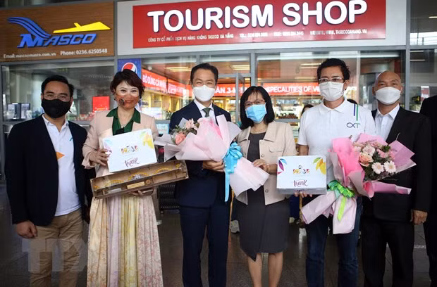 Phó Giám đốc Trung tâm Xúc tiến Du lịch Đà Nẵng Huỳnh Thị Hương Lan (giữa) tặng hoa và quà lưu niệm cho đại diện đoàn khách MICE. Ảnh: Trần Lê Lâm/TTXVN