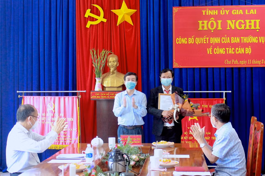 Trưởng ban Tổ chức Tỉnh ủy Huỳnh Quang Thái (bìa trái) thay mặt Ban Thường vụ Tỉnh ủy trao quyết định và tặng hoa chúc mừng tân Phó Bí thư Huyện ủy Chư Pưh Nguyễn Huy Châu. Ảnh: Hồng Thi