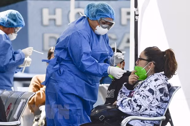 Nhân viên y tế lấy mẫu xét nghiệm COVID-19 cho người dân tại Mexico City, Mexico. Ảnh: AFP/TTXVN