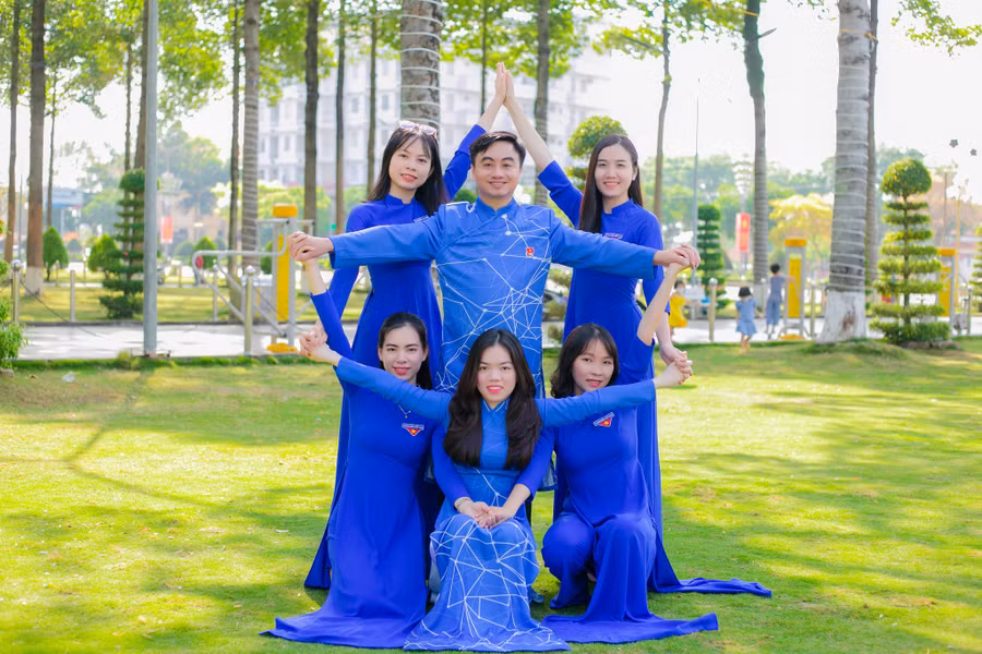 Bí thư Tỉnh đoàn Bình Phước Trần Quốc Duy (đứng giữa) cùng nhóm bạn trẻ hào hứng mặc áo dài của nhà thiết kế Việt Hùng. Ảnh: B.P