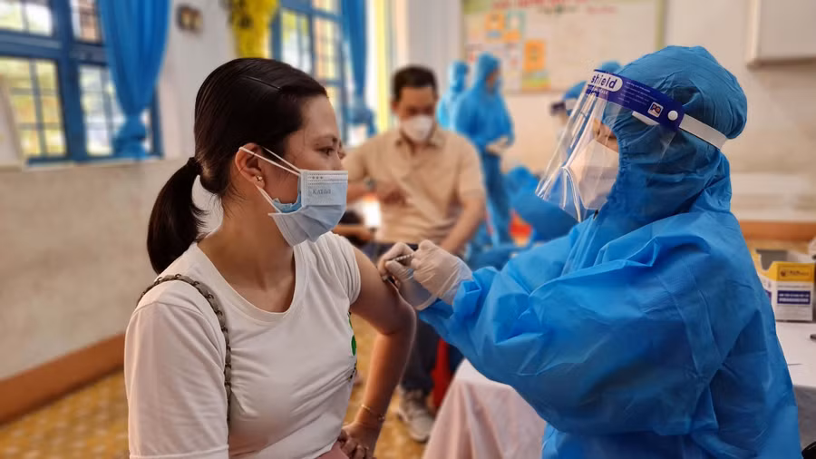 Ảnh 5: Tiêm vắc xin phòng Covid-19 cho người dân tại điểm tiêm Trường Tiểu học Chu Văn An (phường Tây Sơn, TP. Pleiku).