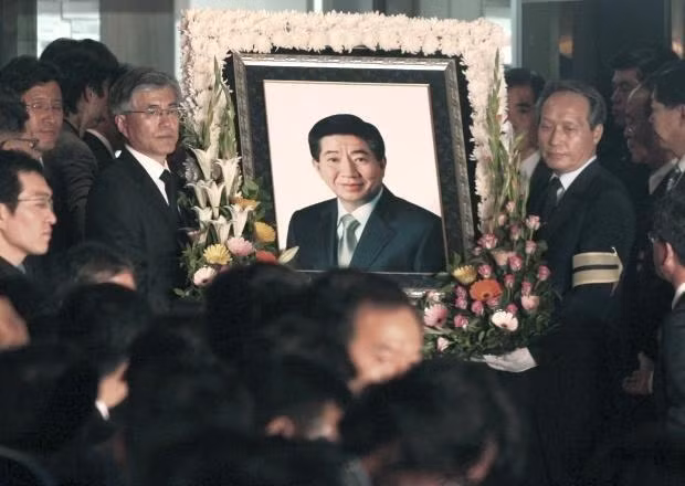  Ông Moon Jae-In (bên trái, đeo kính) nâng di ảnh bạn - tổng thống Roh Moo Hyun.ngày 23/5/2009. Ảnh: AP.