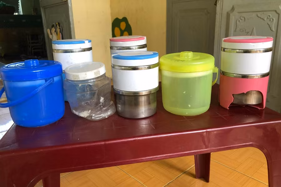 Những hộp nhựa mang cơm cũ kỹ, bể nát vẫn được các em sử dụng. Ảnh: NVCC