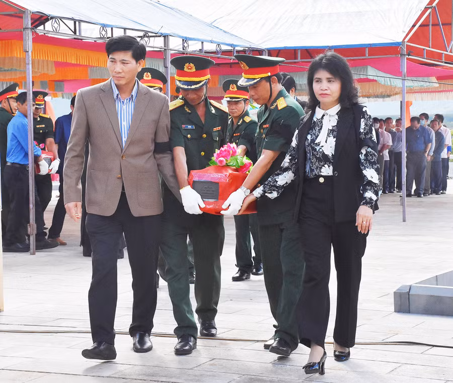 Lãnh đạo tỉnh, huyện thực hiện nghi thức di quách hài cốt liệt sĩ đến nơi an táng. Ảnh: Hà Phương