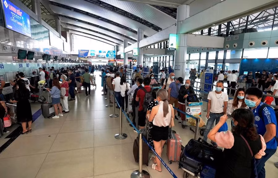 Hành khách xếp hàng dài làm thủ tục chuyến bay. (Ảnh: CTV/Vietnam+) Hành khách xếp hàng dài làm thủ tục chuyến bay. (Ảnh: CTV/Vietnam+)