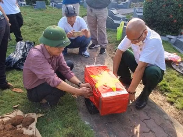 Anh Hùng cùng với ông Nguyễn Sỹ Hồ trong một chuyến bốc mộ liệt sĩ. Ảnh: Quang Viên