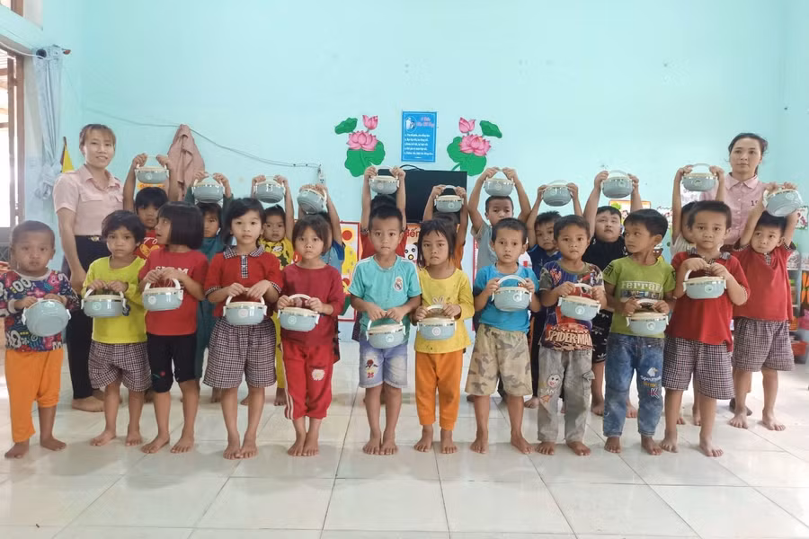Trò nghèo miền núi nhận cặp lồng mới mà nhóm trao tặng. Ảnh: NVCC