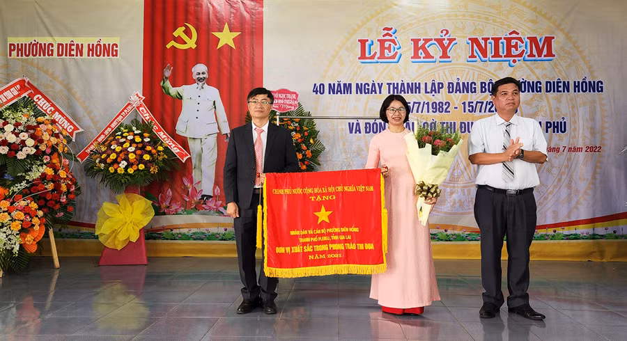 Thừa ủy quyền của Thủ tướng Chính phủ, đồng chí Kpă Thuyên (bìa phải)-Phó Chủ tịch UBND tỉnh tặng cờ thi đua cho nhân dân và cán bộ phường Diên Hồng. Ảnh: Phan Lài