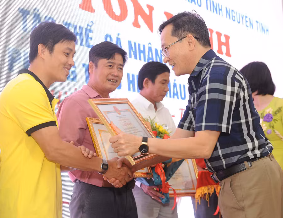 Anh Trần Vũ (bìa trái) được Sở Y tế tặng giấy khen vì thành tích vận động và tham gia hiến máu cứu người năm 2022. Ảnh: Hồng Thương