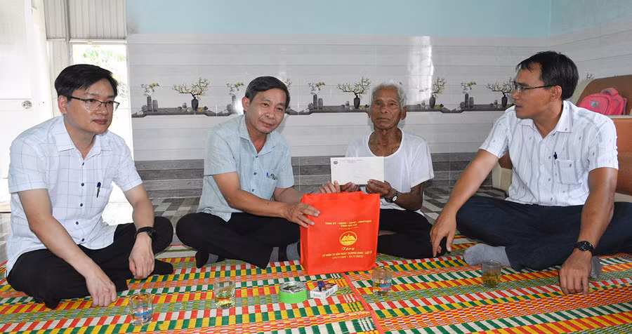 Trưởng Ban Tuyên giáo Huỳnh Thế Mạnh (thứ 2 từ trái qua) tặng quà ông Đinh Triêng- thương binh, làng Lợt, xã Kông Bơ La. Ảnh: Đinh Yến