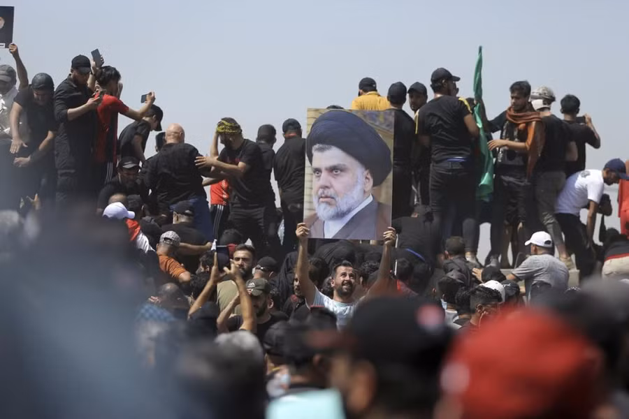 Một người biểu tình giơ hình giáo sĩ Muqtada al-Sadr ở Baghdad, Iraq ngày 30-7. 