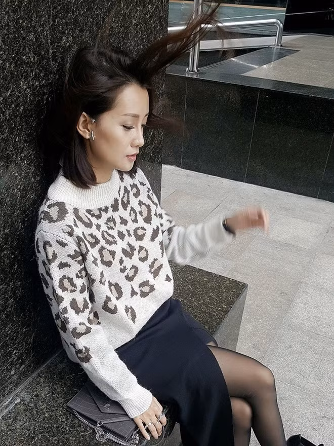 BTV Quỳnh Chi chọn áo len họa tiết mix kèm váy đen xẻ khoe cặp chân dài.