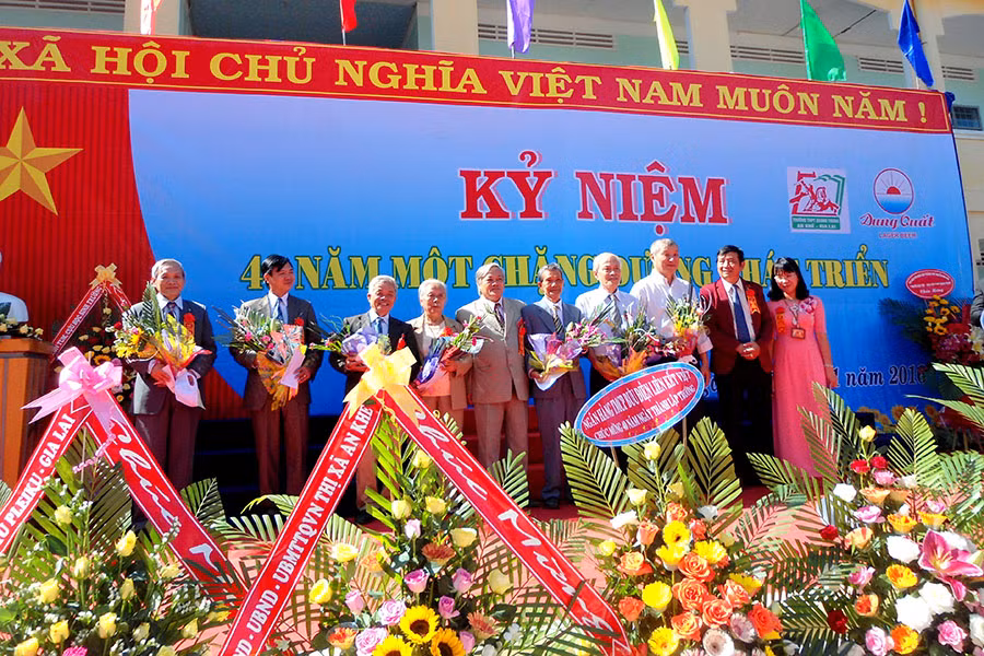 Ban Giám hiệu Nhà trường tặng hoa cho các thầy-cô giáo nguyên là cán bộ, giáo viên trong trường. Ảnh: Hồng Thi 