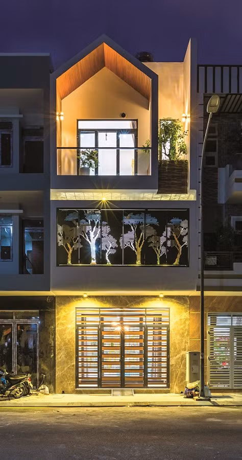 Mặt tiền ngôi nhà lung linh khi lên đèn. Hệ cửa thép tầng 2 trở thành một bức tranh liên hoàn đầy cuốn hút.