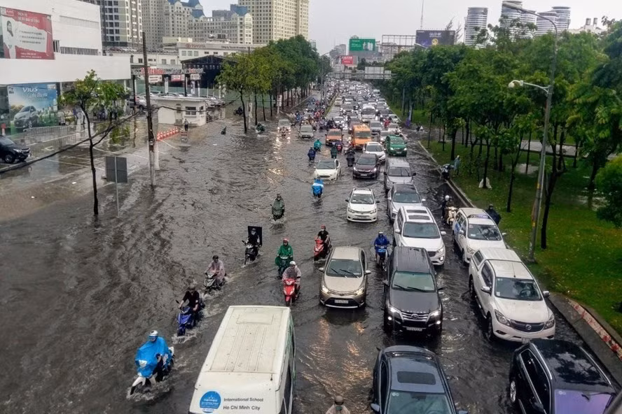 Hàng ngàn người dân TPHCM vất vả lội nước trên đường Nguyễn Hữu Cảnh trong cơn mưa chiều 3.6. Ảnh: Minh Quân
