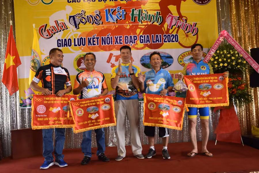 Ông Nguyễn Công Sự-Chủ nhiệm Câu lạc bộ xe đạp Gia Lai trao cờ lưu niệm cho các đơn vị tham gia tại chương trình. Ảnh: Hà Phương