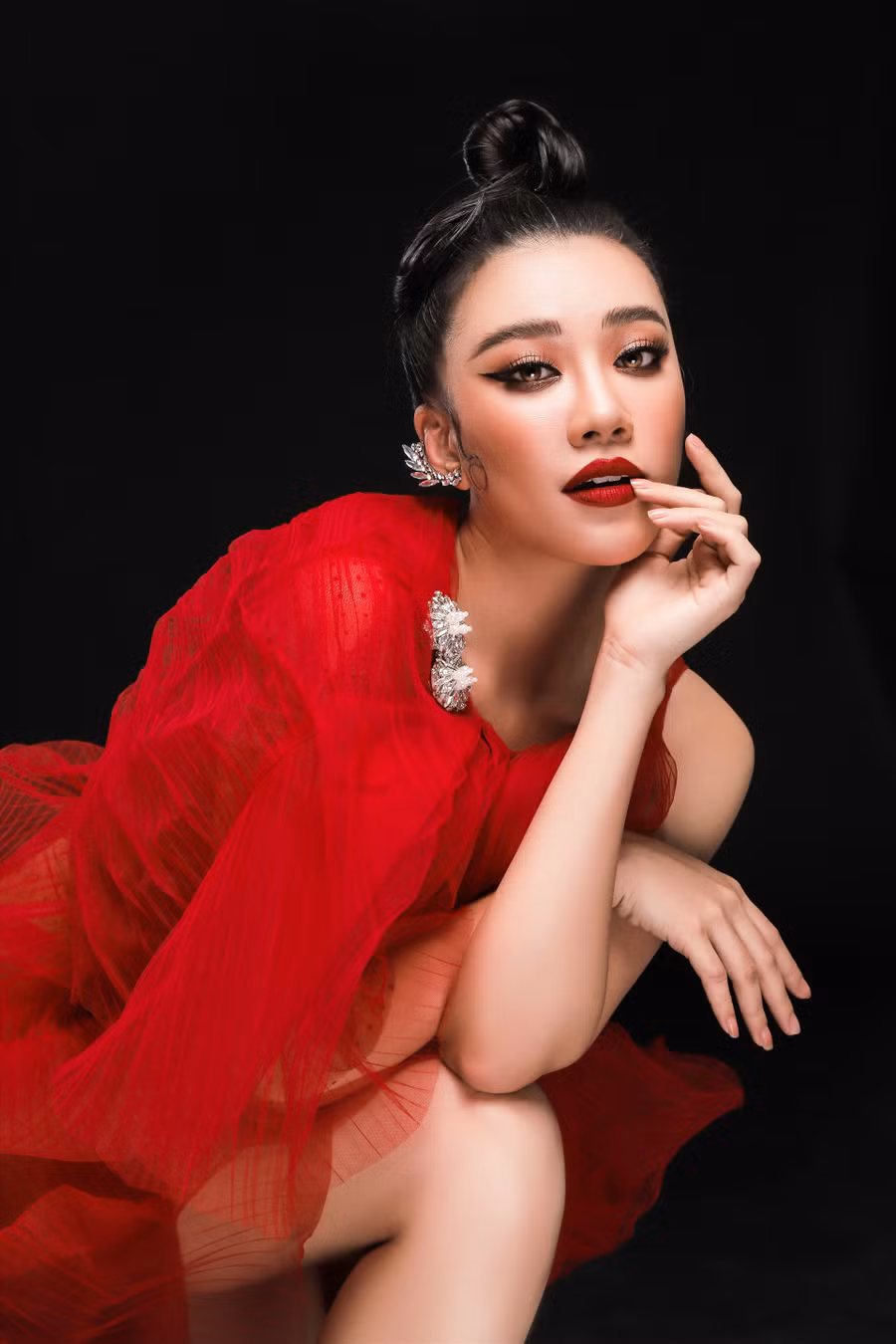 Để đánh dấu cột mốc giảm cân của mình, Á hậu Kim Duyên thực hiện bộ ảnh mới trong bộ váy lưới màu đỏ, kiểu dáng bồng bềnh. Vốn quen thuộc với khán giả bằng hình ảnh tóc thẳng suôn dài, lần này Kim Duyên chọn kiểu tóc búi cao, khoe đường nét gương mặt hậu giảm cân. Ảnh: Nguyễn Du.