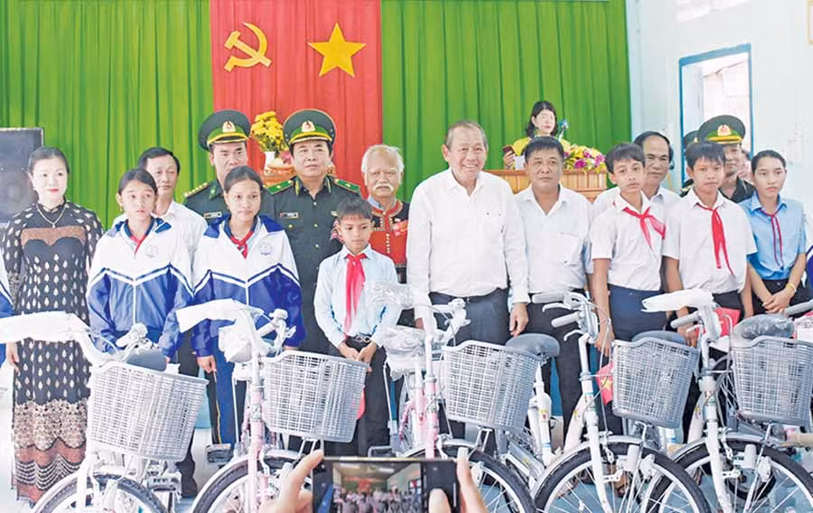 Phó Thủ tướng Thường trực Chính phủ Trương Hòa Bình (thứ 7 từ phải sang) tặng xe đạp cho học sinh khó khăn ở các xã Ia Dom, Ia Nan, Ia Pnôn (huyện Đức Cơ). Ảnh: M.T Phó Thủ tướng Thường trực Chính phủ Trương Hòa Bình