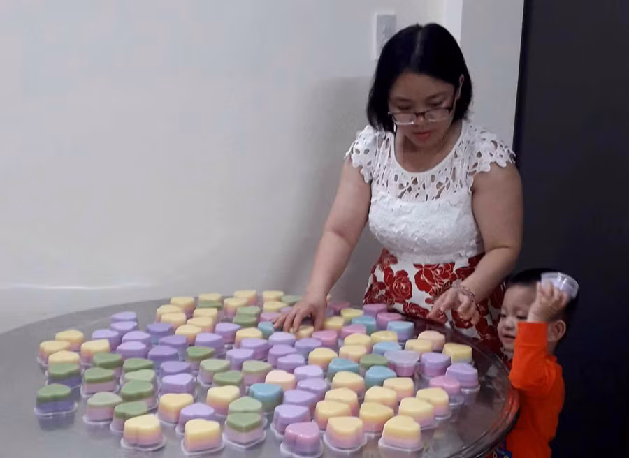 Chị Ngân bên một mẻ bánh rau câu nấu từ màu tự nhiên vừa hoàn thành cho khách đặt ăn trong dịp Tết. Ảnh: Hải Lê