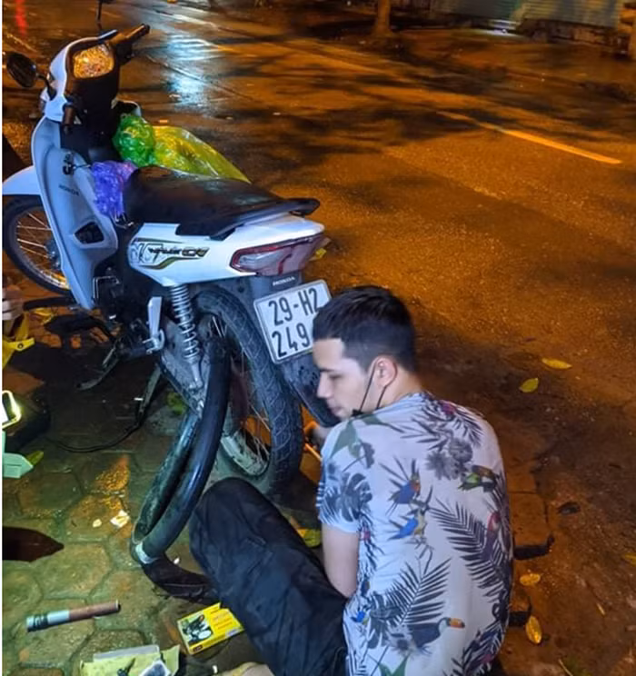 Anh Minh Hiếu đang sửa xe trên phố Hoàng Hoa Thám.