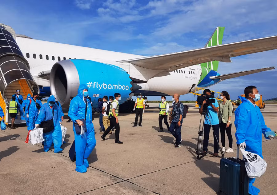 Để đảm bảo an toàn dịch bệnh, các du khách mặc đồ bảo hộ trong suốt chuyến bay. Ảnh: Hiền Lương
