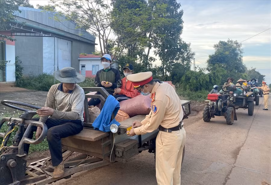 Cảnh sát giao thông Công an huyện Đắk Mil dán decal cho xe máy cày. Ảnh: Phan Tuấn