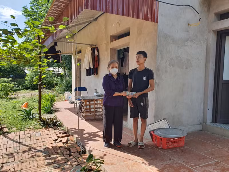 Bà Thuận trao tiền hỗ trợ cho một học sinh được Hội đỡ đầu.
