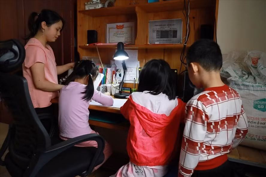 Một phụ huynh hướng dẫn con học trực tuyến Ảnh: Lao Động