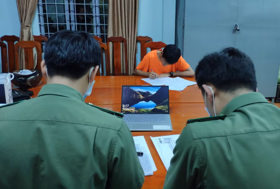 P.T ( áo cam) đang làm việc với cơ quan chức năng. Ảnh: CTV