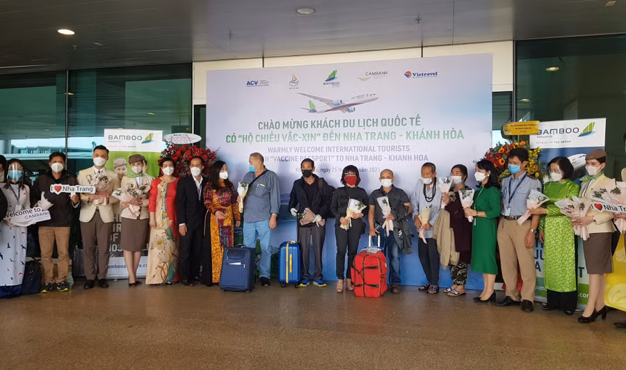 Lãnh đạo ngành du lịch Khánh Hòa và Cảng hàng không quốc tế Cam Ranh tặng hoa và quà lưu niệm cho du khách đến du lịch tại Khánh Hòa. Ảnh: Hiền Lương