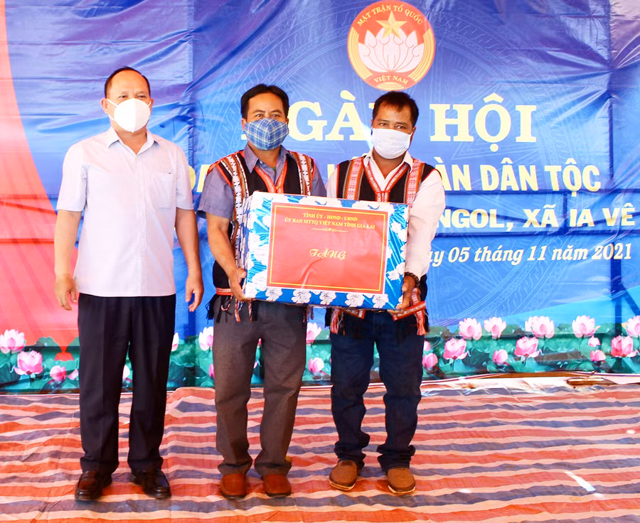 Đồng chí Rah Lan Chung (bìa trái)-Phó Bí thư Tỉnh ủy, Trưởng ban Nội chính Tỉnh ủy tặng phần quà cho người dân làng O Ngol. Ảnh: Phan Lài
