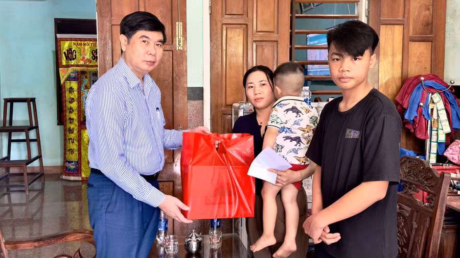 Phó Chủ tịch UBND tỉnh Lâm Hải Giang (bìa trái) tặng quà động viên gia đình có người thân bị tai nạn lao động tại thôn Thọ Tân Bắc, xã An Nhơn Tây. Ảnh: Minh Hoàng