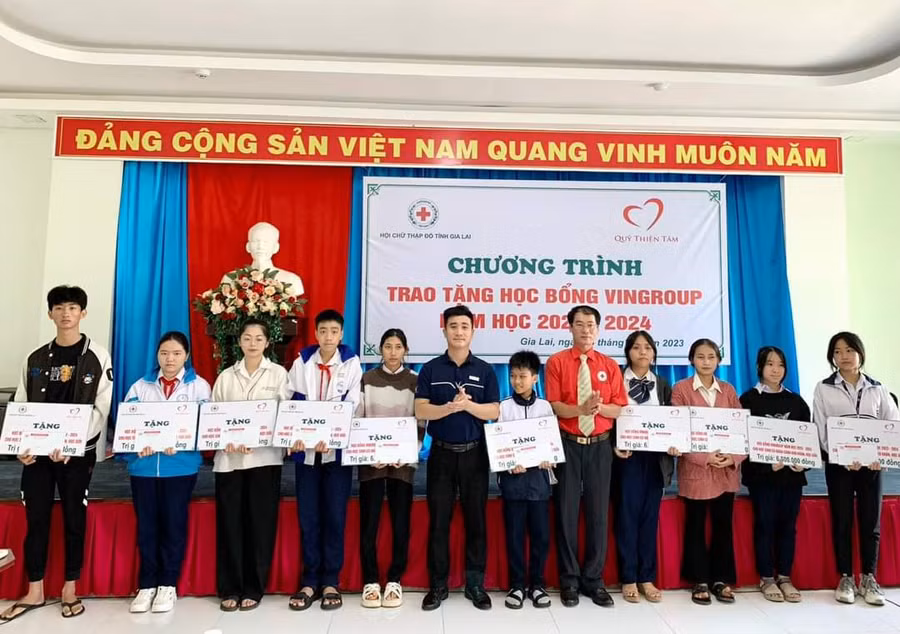 Ông Dương Đình Diện (thứ 5 từ phải sang)-Chủ tịch Hội Chữ thập đỏ Gia Lai cùng đại diện Qũy Thiện Tâm-Tập đoàn Vingroup trao học bổng cho các em học sinh. Ảnh: Đ.D