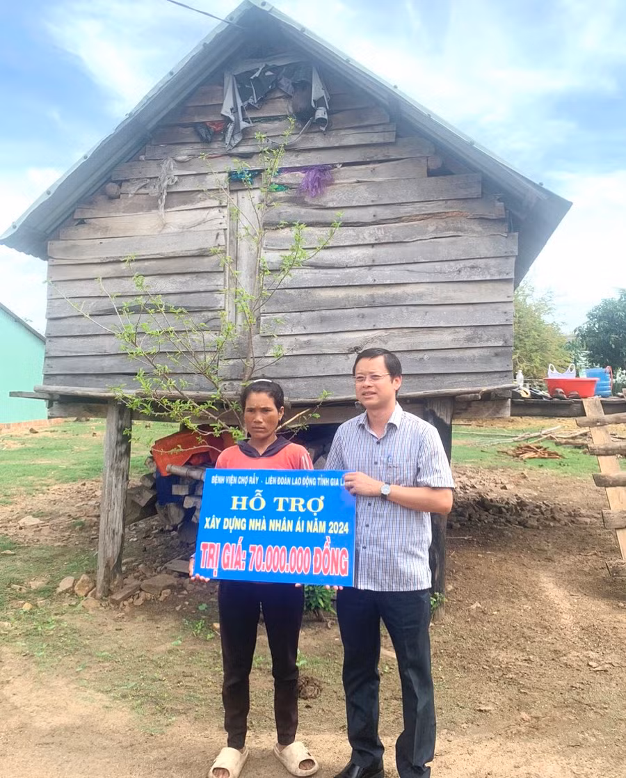 Ông Nguyễn Hoàng Phong-Tỉnh ủy viên, Chủ tịch LĐLĐ tỉnh Gia Lai trao tiền hỗ trợ sửa chữa nhà ở cho gia đình chị Đinh Nenh. Ảnh: Mỹ Lệ