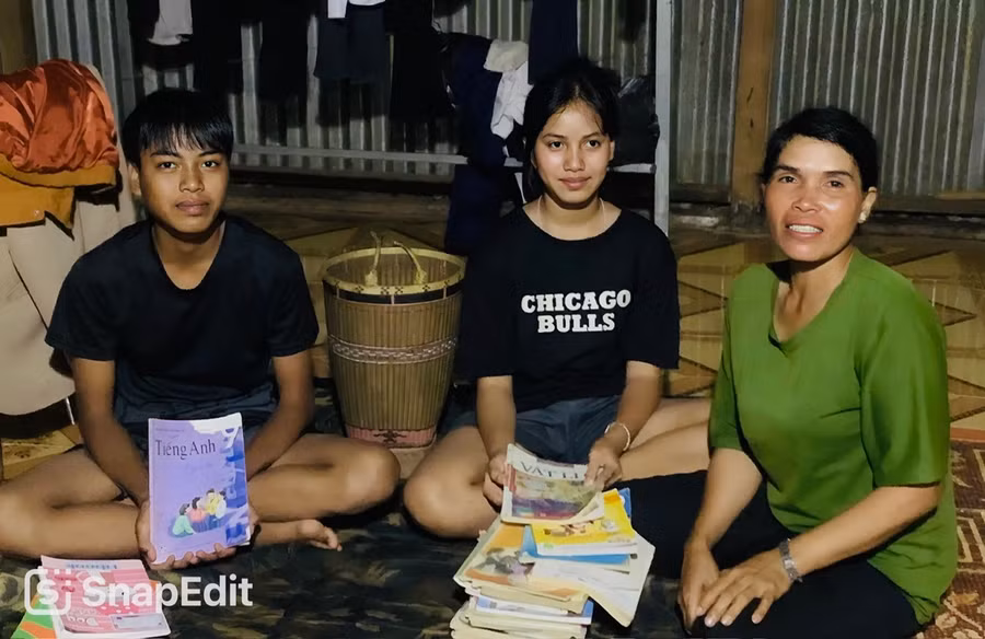 Chị Ksor H’Up (làng Breng 1, xã Ia Dêr, huyện Ia Grai) cùng con trai Ksor Phước và con gái Ksor H'Liêm kiểm tra đồ dùng học tập, sách vở cho con. Ảnh: Đinh Yến