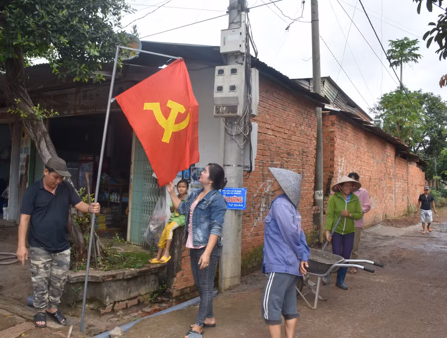 Bà Hà Thị Thắm-Bí thư Chi bộ kiêm Trưởng thôn 6 (thứ 3 từ trái sang) cùng người dân trong thôn dọn dẹp đường làng, ngõ xóm, treo cờ Tổ quốc chuẩn bị đón Tết Độc lập. Ảnh: Đinh Yến