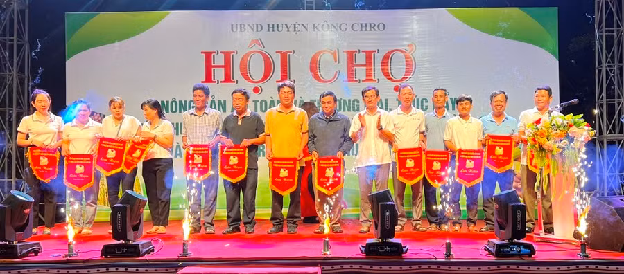 Ban tổ chức trao cờ lưu niệm cho các xã, thị trấn, đơn vị, doanh nghiệp, hợp tác xã tham gia Hội chợ. Ảnh: Đinh Yến