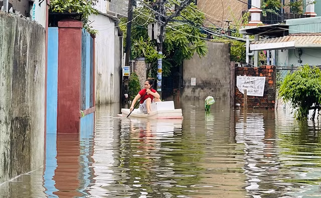 Vì sao đô thị ngập nặng ? - Ảnh 1. Một số người phải dùng phao di chuyển trong khu dân cư tại P.Hòa Khánh Nam (Đà Nẵng). Ảnh: HUY ĐẠT