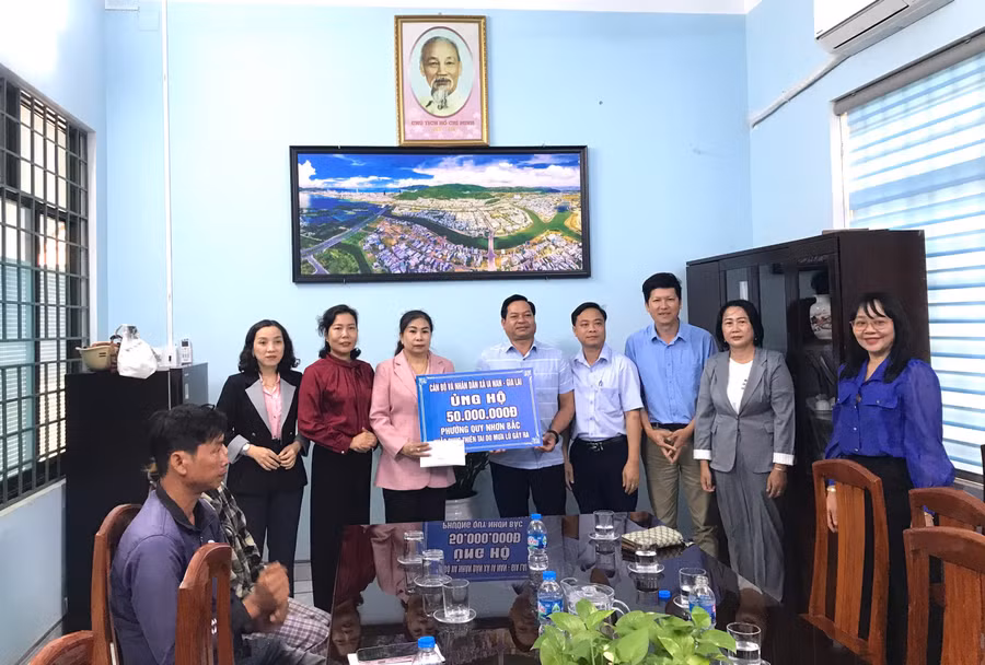 Phó Bí thư Thường trực Đảng ủy xã Ia Nan Rơ Châm Khiêm (thứ 5 từ phải sang) và các thành viên đoàn công tác trao 50 triệu đồng hỗ trợ phường Quy Nhơn Bắc. Ảnh: Đoàn Bình