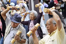 Người cao tuổi Nhật Bản tập thể dục trong khuôn viên một ngôi chùa ở Tokyo để kỷ niệm Ngày Kính trọng Người cao tuổi của Nhật Bản vào ngày 21-9-2009. Ảnh: AFP