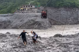 Người dân Nepal dùng cáp treo vượt sông Trishuli sau lũ quét. Ảnh: AP